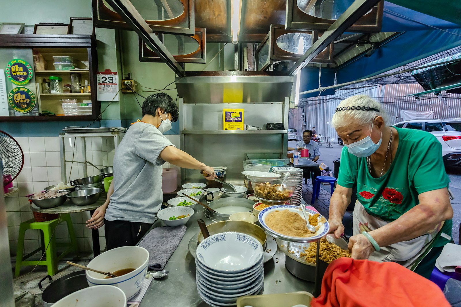 Two people preparing and serving food in a kitchen
